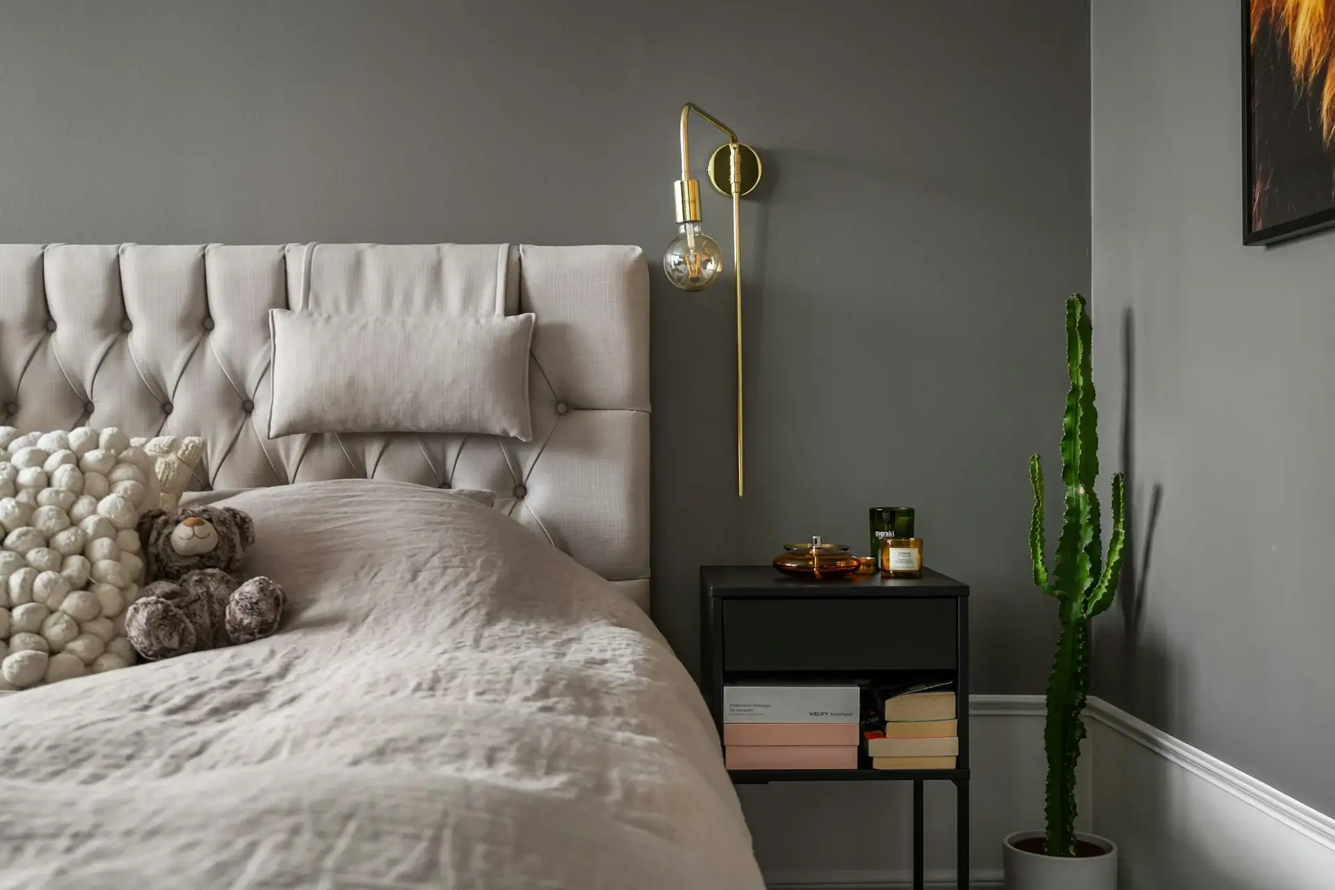 Modern bedroom with gray accent wall, layered pillows, and soft neutral bedding.