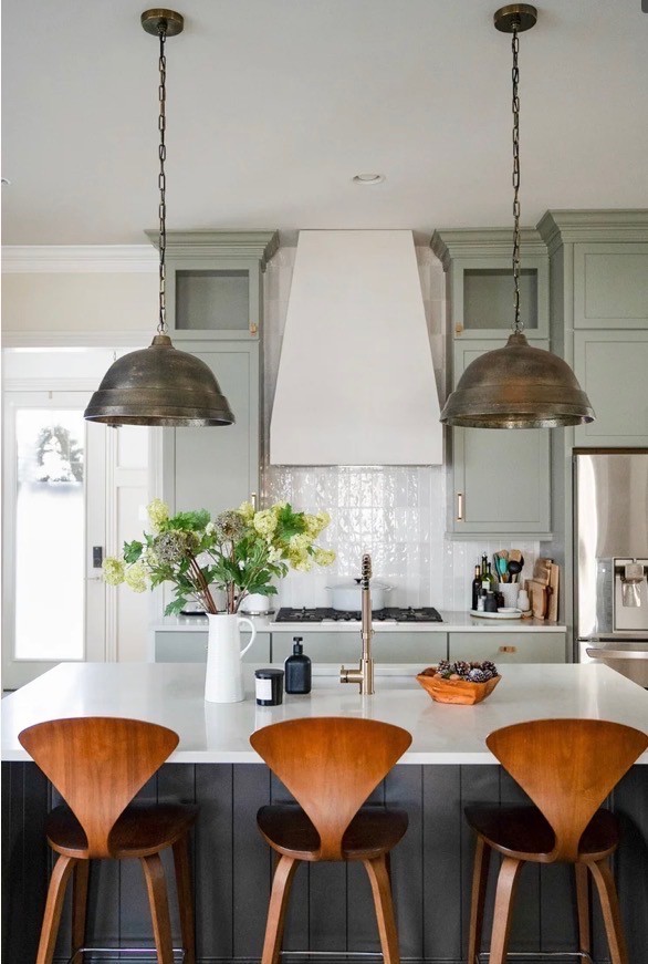 A serene outdoor lounge area with two chairs surrounded by lush greenery and natural light streaming in.