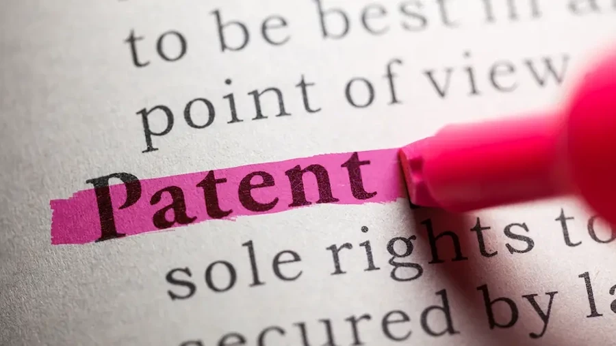 Close-up of the word “Patent” highlighted in pink on a printed page.