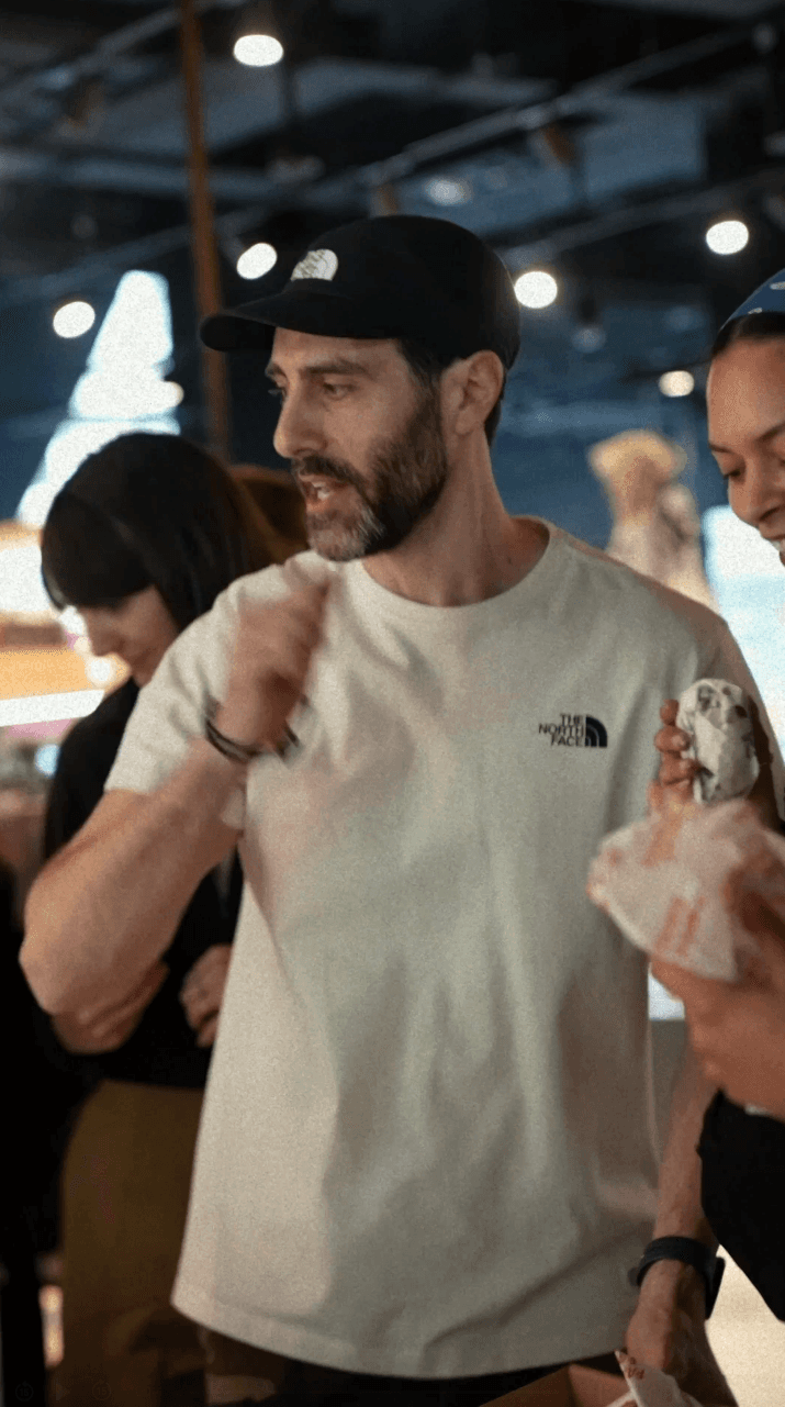 Bride in white dress walking on street, man in background