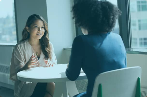 Two professionals engaged in a focused conversation, representing thoughtful and collaborative approaches to job evaluation.