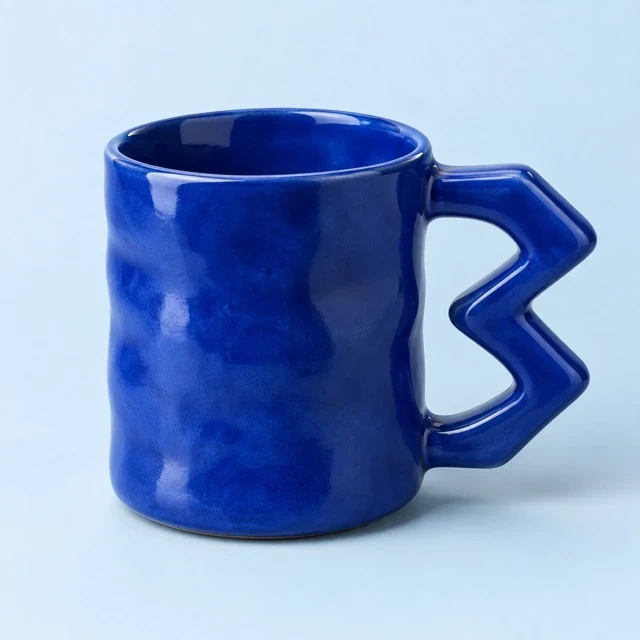 Cobalt blue ceramic mug with a sculptural zigzag handle