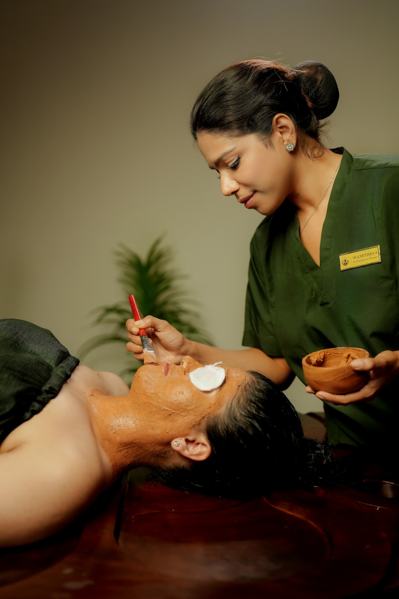 Woman receiving oil treatment on her forehead