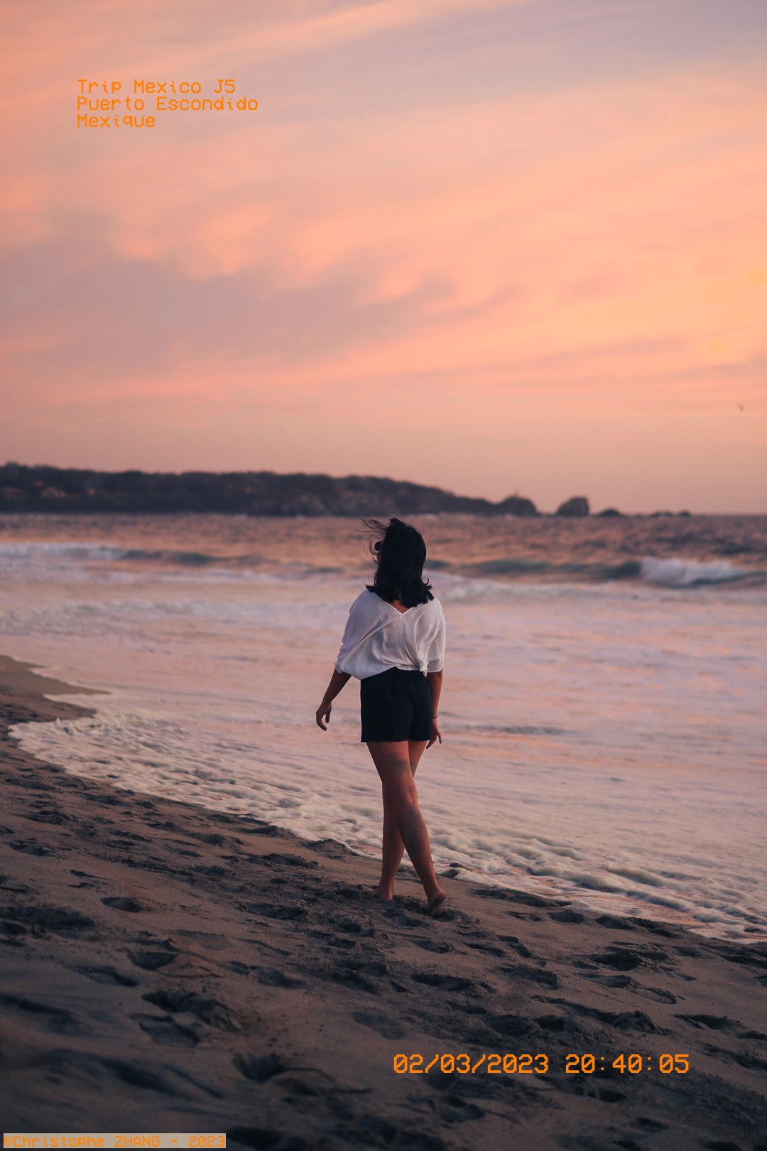 Coucher de soleil sur la plage de Puerto Escondido avec une femme profitant de la vue.
