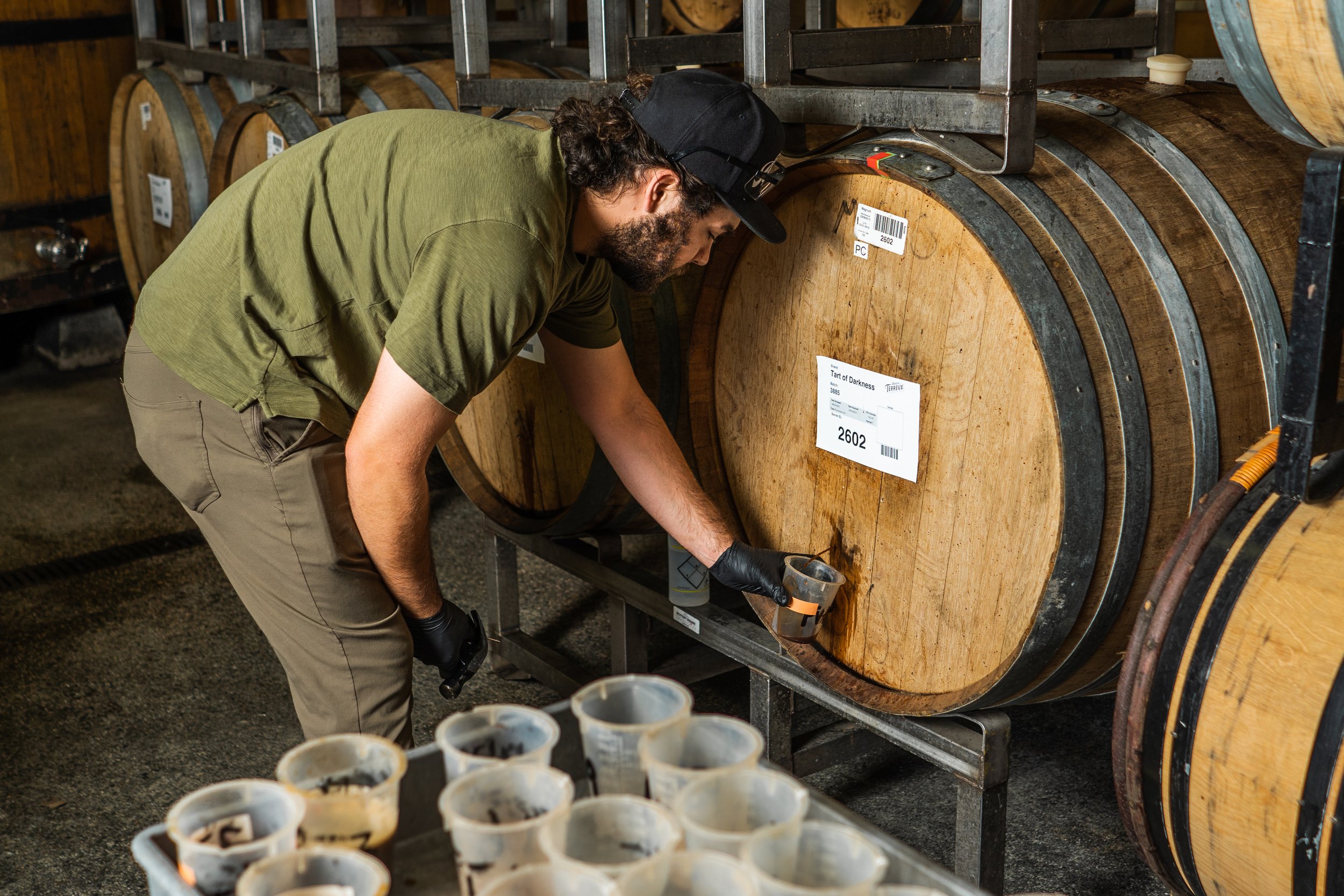 Brewer filling glasses from barrel at The Bruery