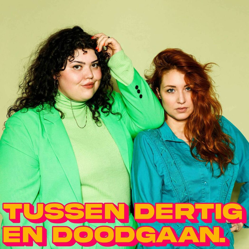 Two people dressed in green and purple clothes standing together.