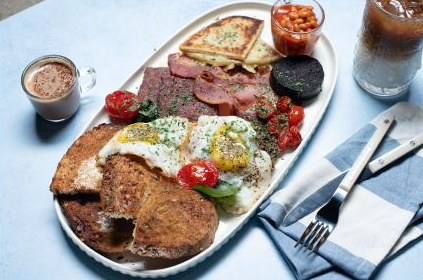 Full Scottish breakfast platter with eggs, bacon, black pudding, French toast and beans