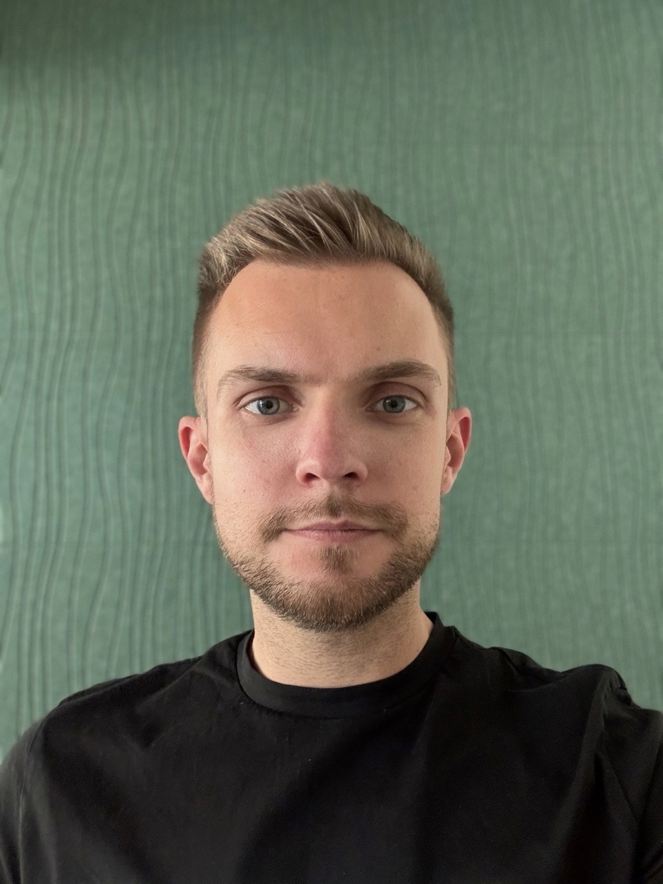Profile portrait of a man in a white shirt against a light background