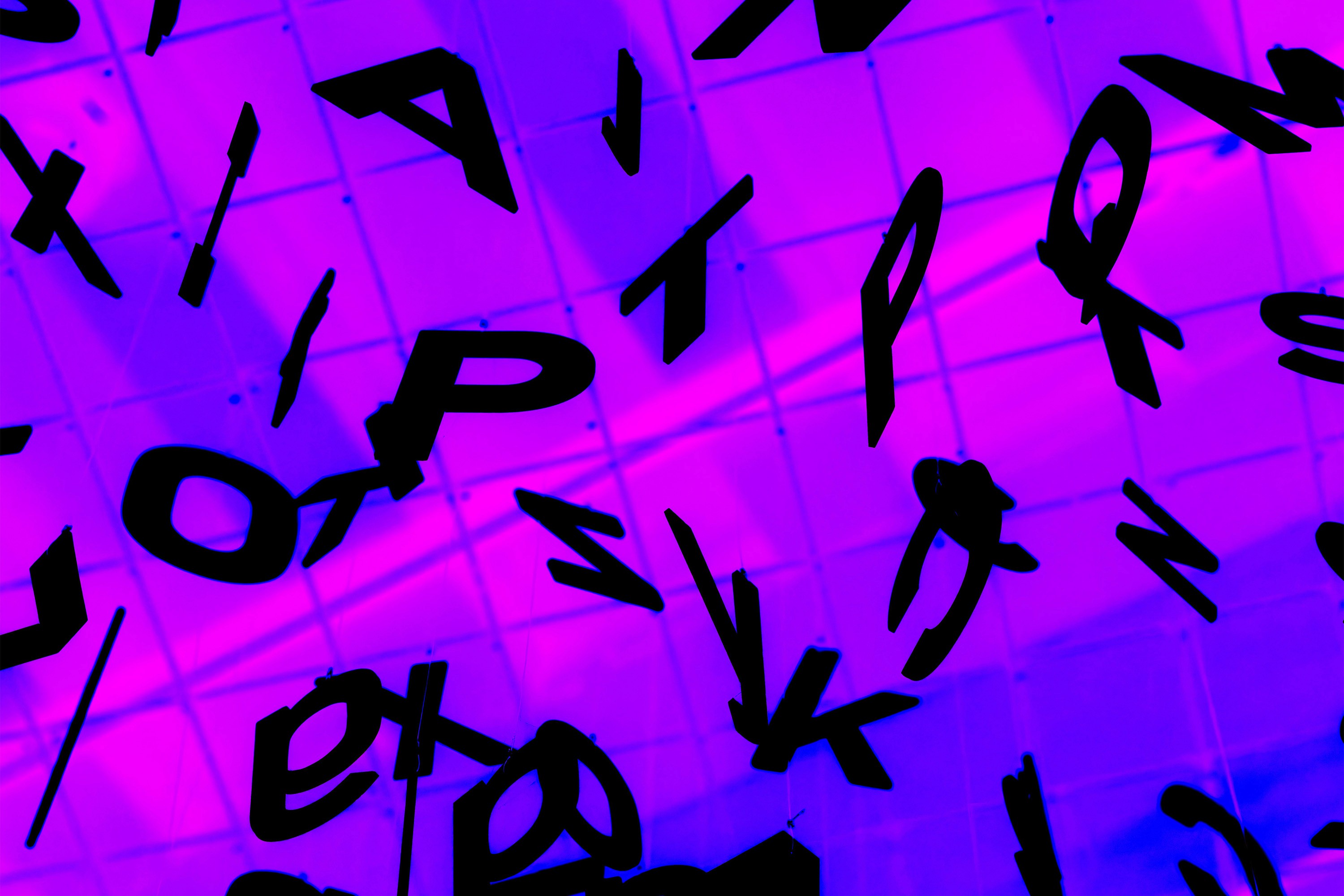 Abstract purple illustration of scattered hand-drawn letterforms, representing typography and fonts.