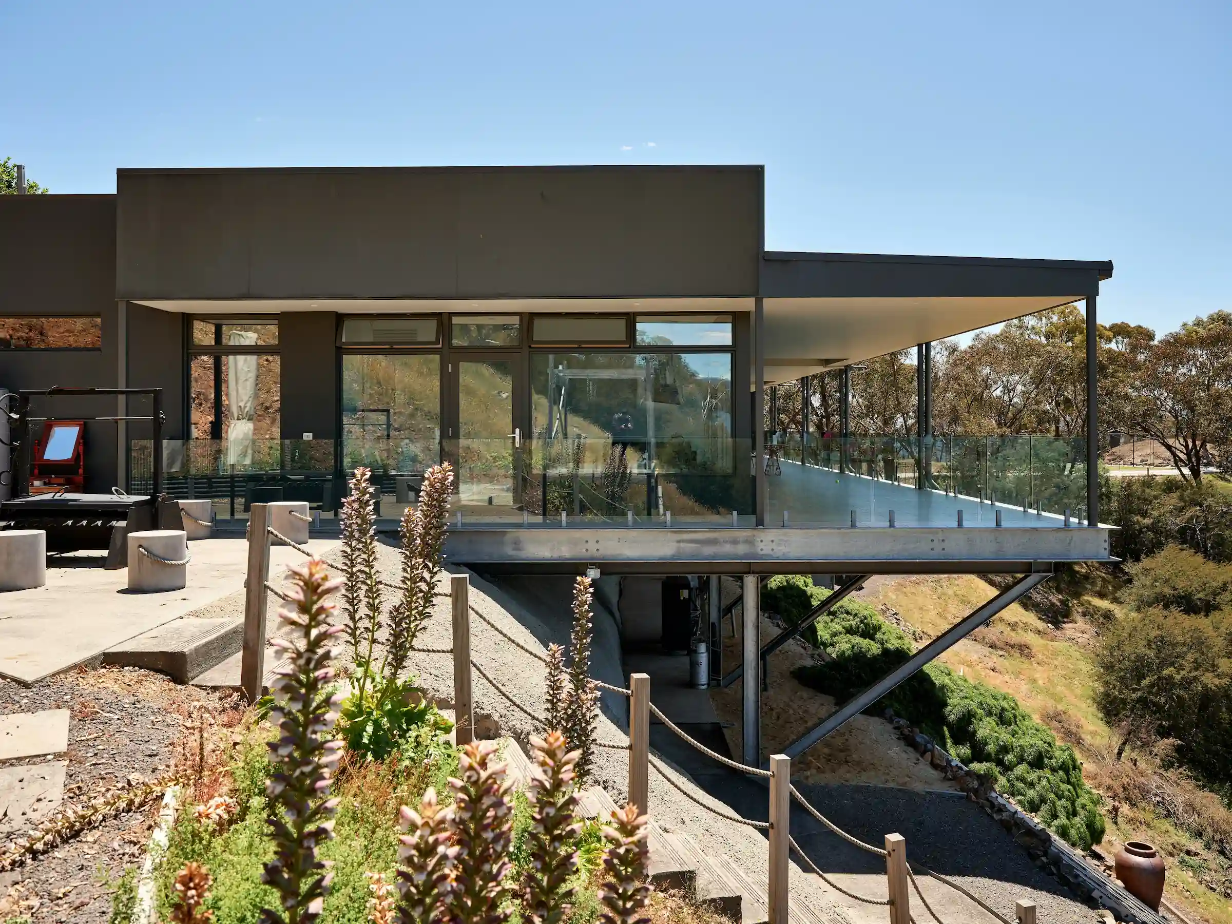 Modern timber-clad residence with horizontal wood facade and geometric volumes set on manicured lawn