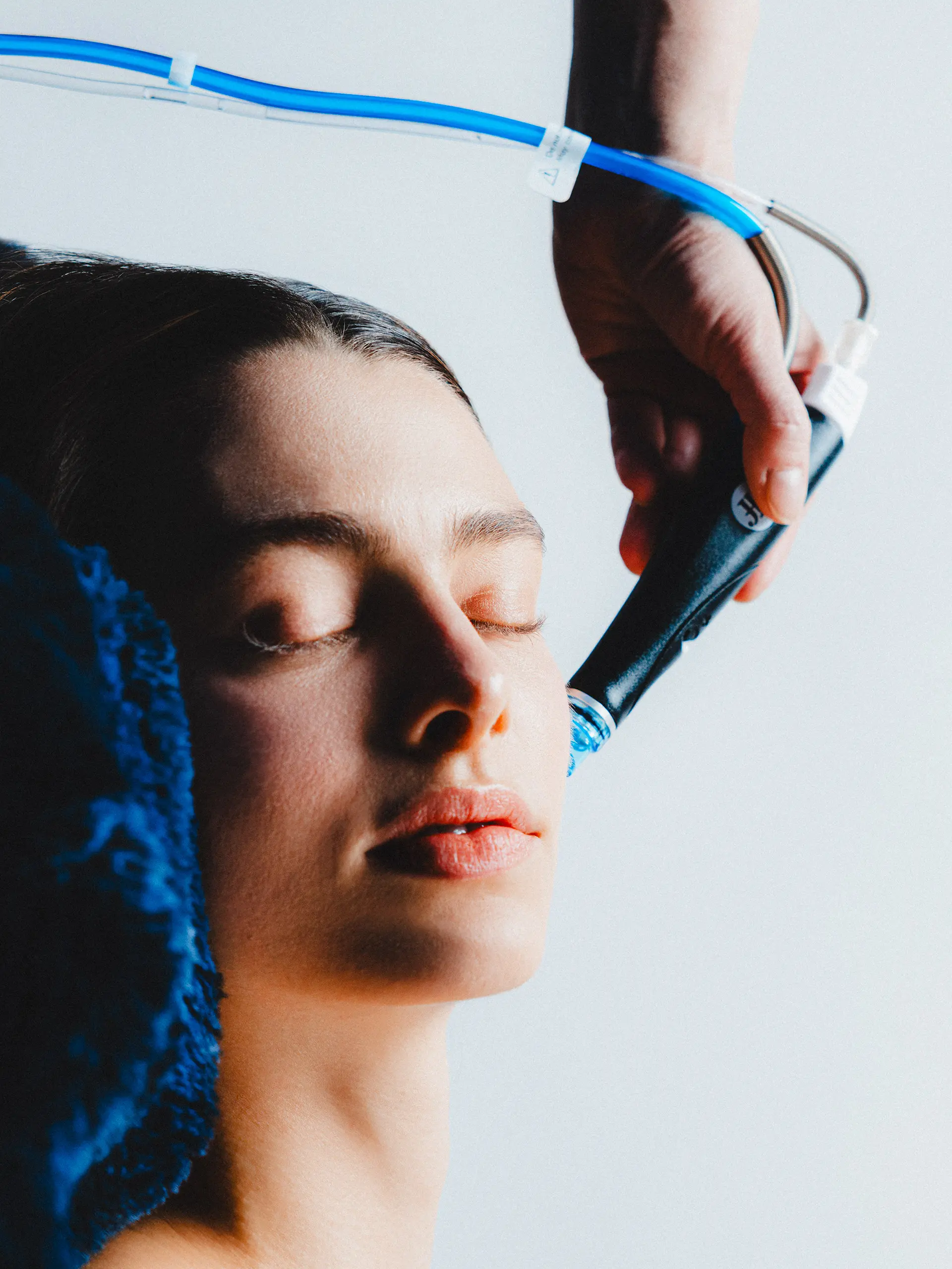 Woman receiving hydrodermabrasion facial treatment for clear skin.