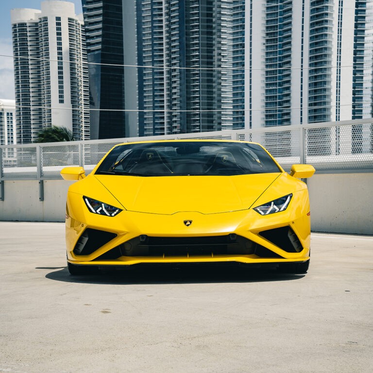 Head-on front view of a yellow Lamborghini Huracán EVO Spyder, showcasing its aggressive design and iconic Y-shape LED lights.