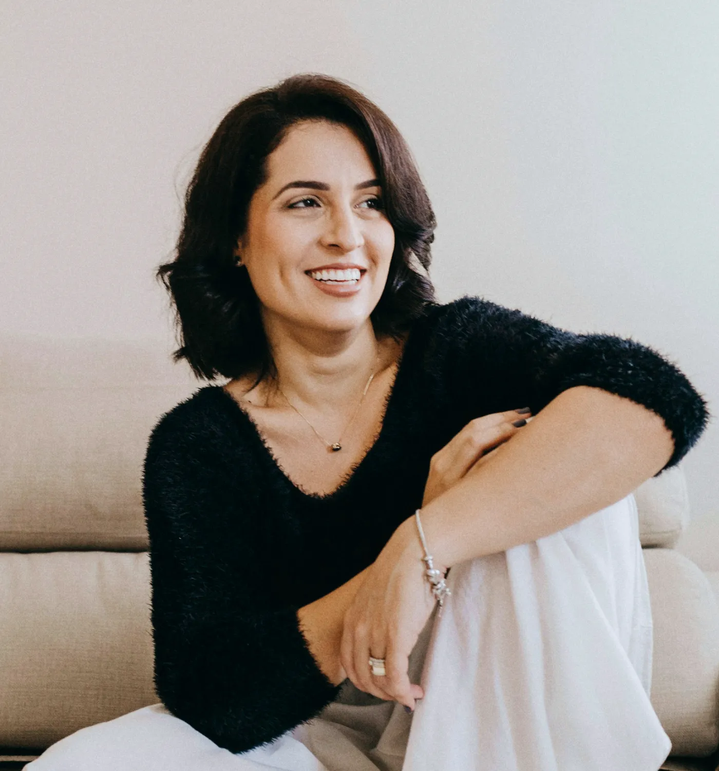 Smiling provider relaxing on a couch in her clinic