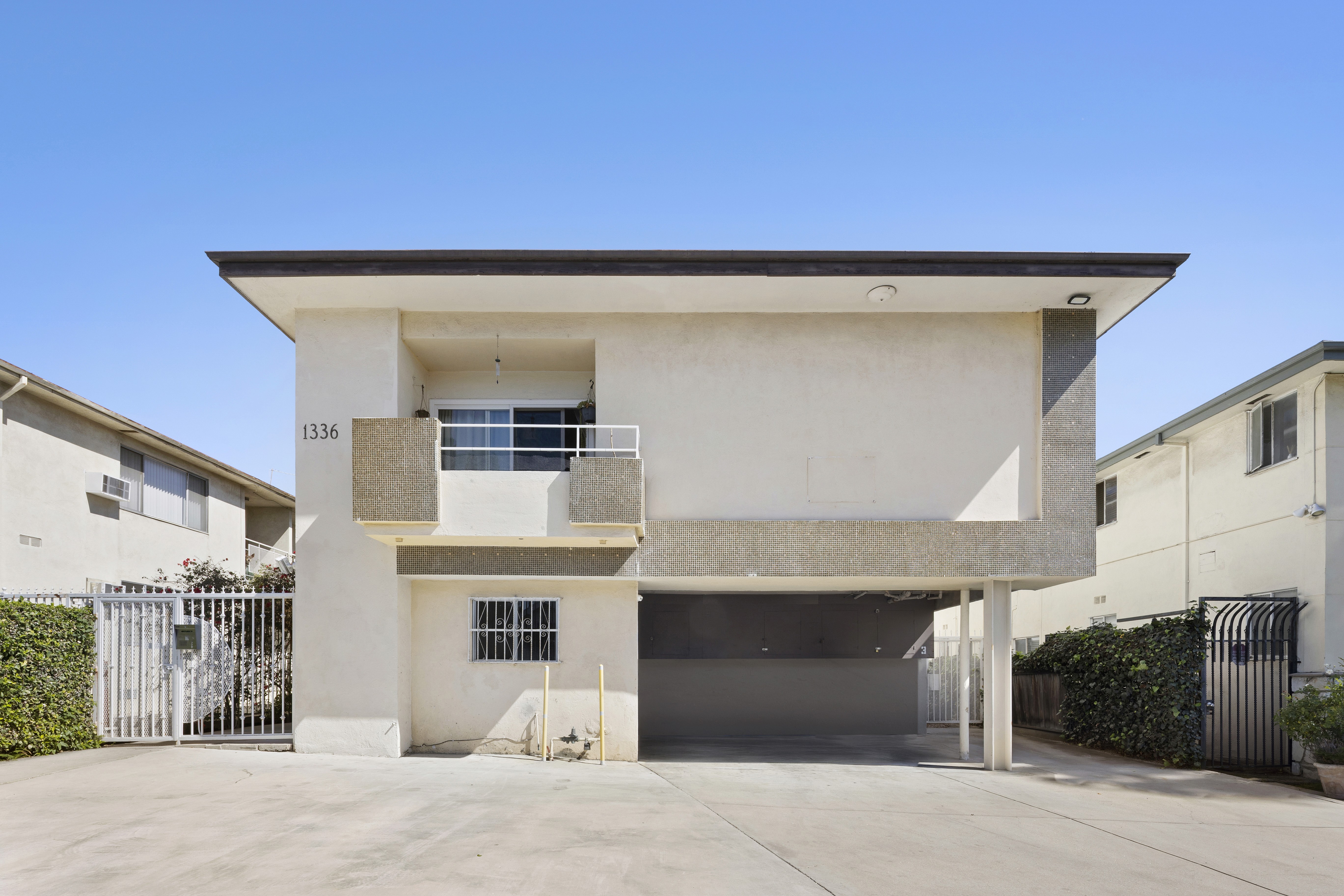 Front exterior of two-story multifamily building with carport parking at 1336 N Citrus Ave.