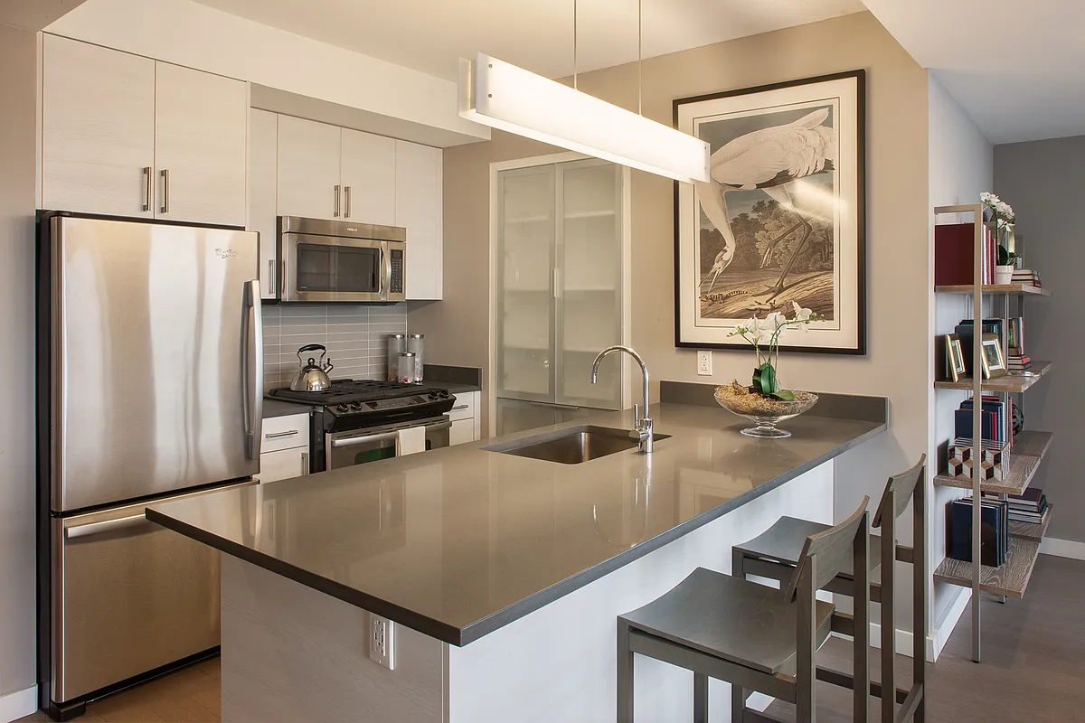 A well-equipped kitchen showcasing stainless steel appliances alongside a functional bar for socializing and dining.