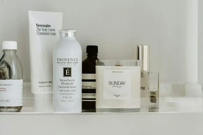 A row of skincare bottles and jars arranged on a white shelf