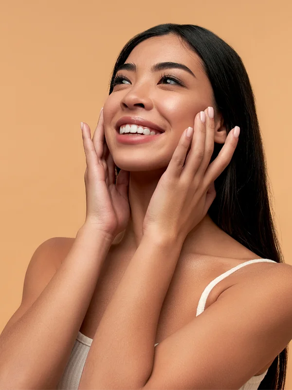 Smiling woman touching hydrated skin after air injector treatment.