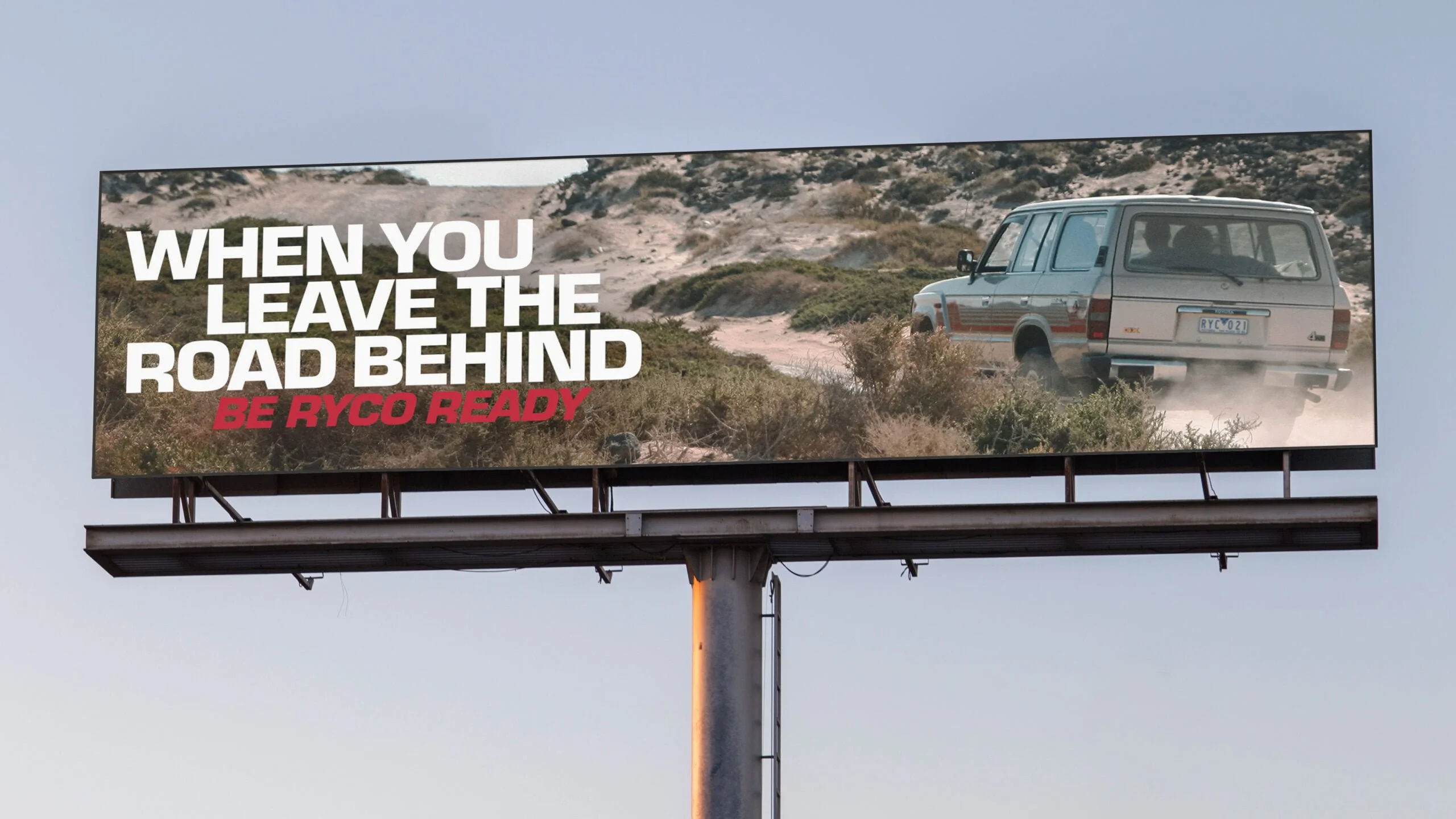 Ryco billboard: 'When you leave the road behind. Be Ryco ready.' with an old 4WD driving through coastal scrub