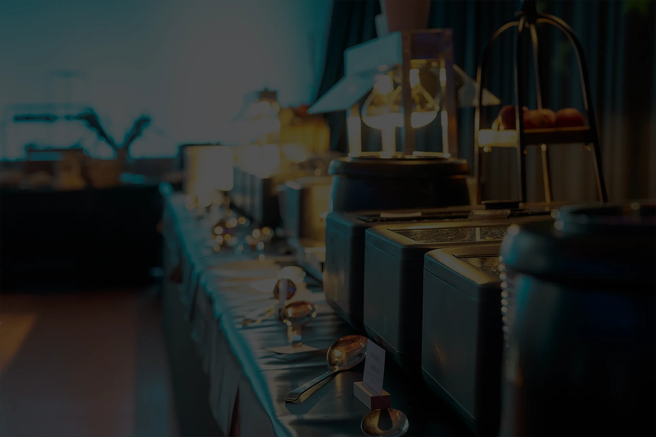Dimly lit room with sunlight filtering through curtains, casting shadows on a green marble table with a single plate of pasta in the center.