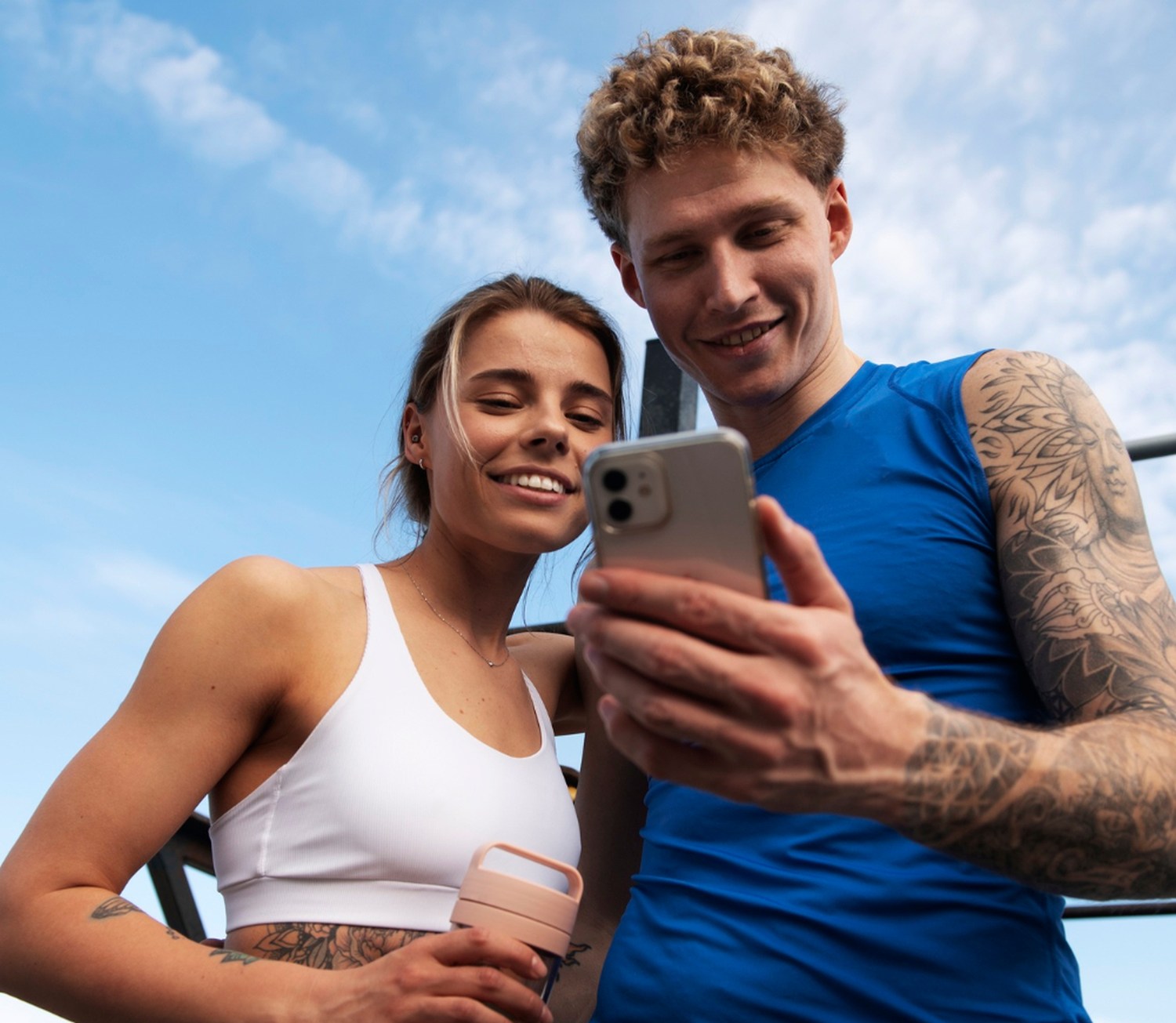 Sportowcy analizują wyniki treningu w aplikacji na smartfonie po bieganiu