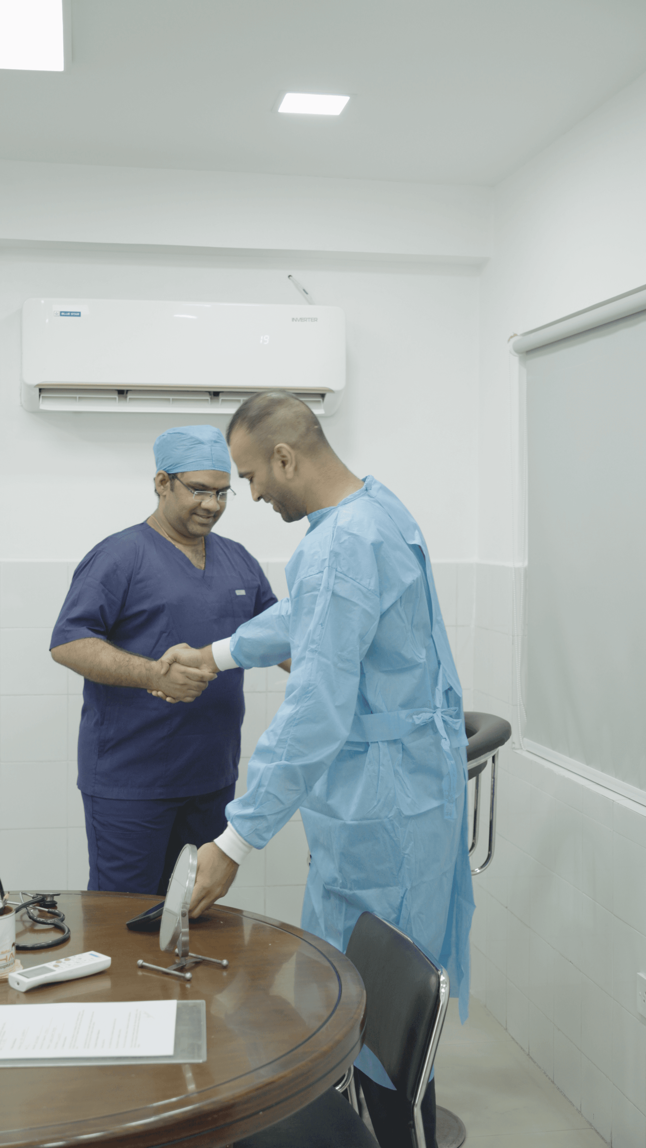 Modern glass office building with white framing, lawn, trees, and clear sky