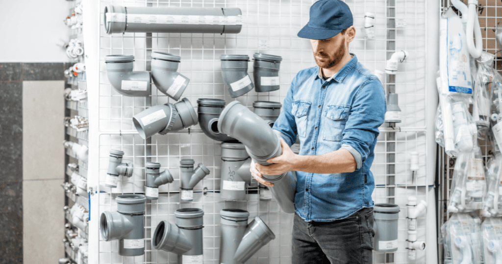 Man inspecting plumbing parts in a hardware store.