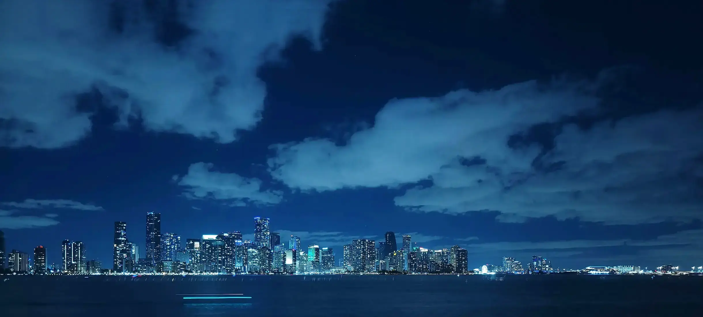 Dubai skyline at night with waterfront and high-rise buildings