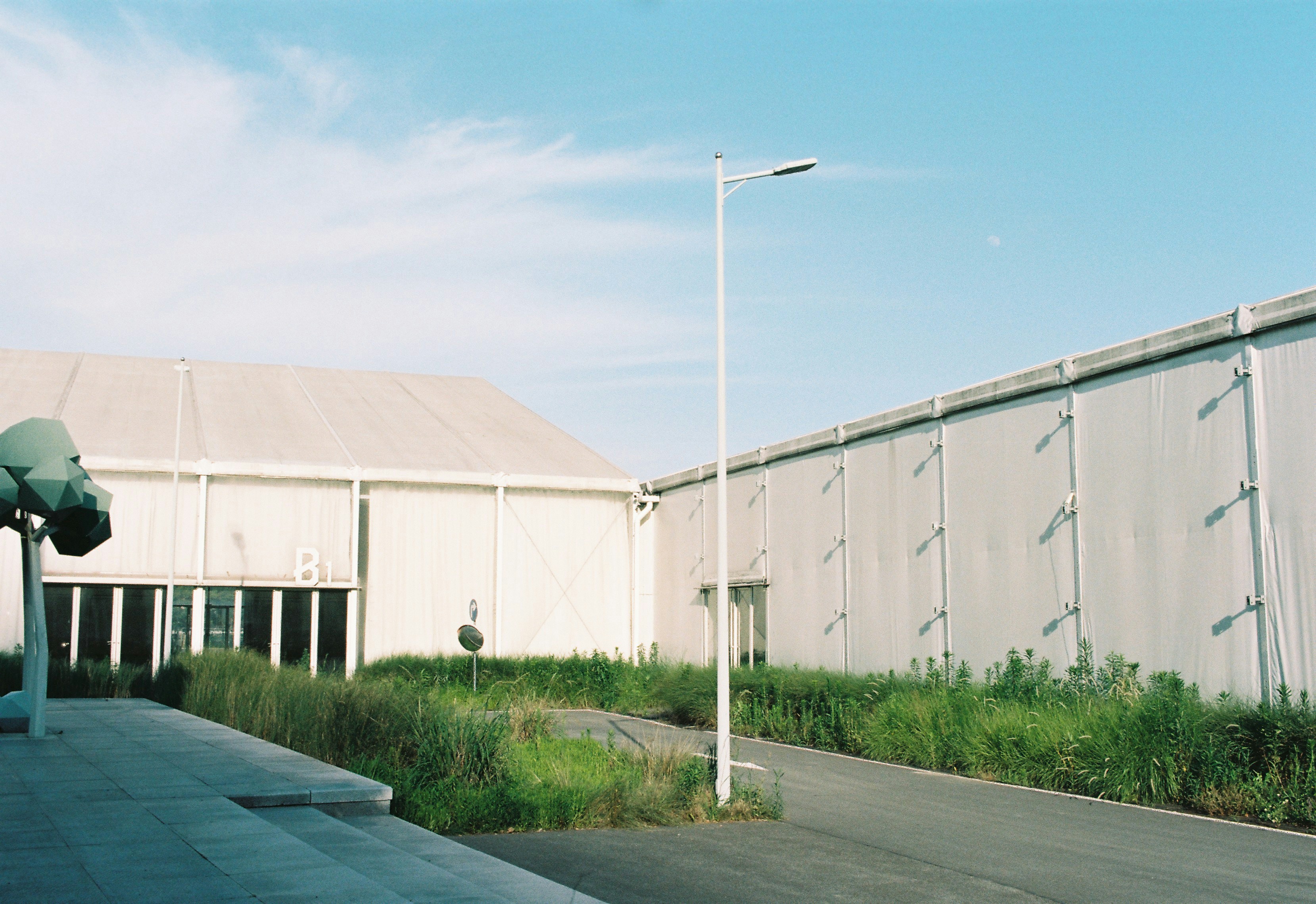 Large, white building under a bright, blue sky.