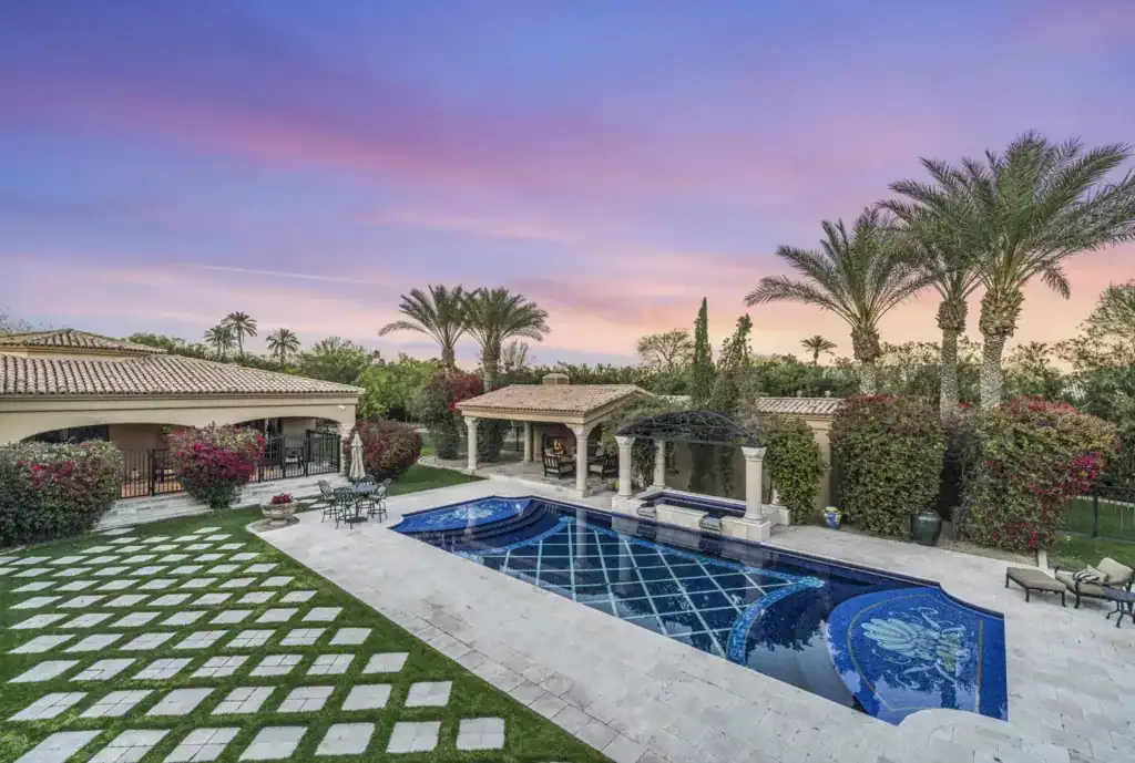 Beautiful mosaic pool featuring intricate waterline border designs at sunset.