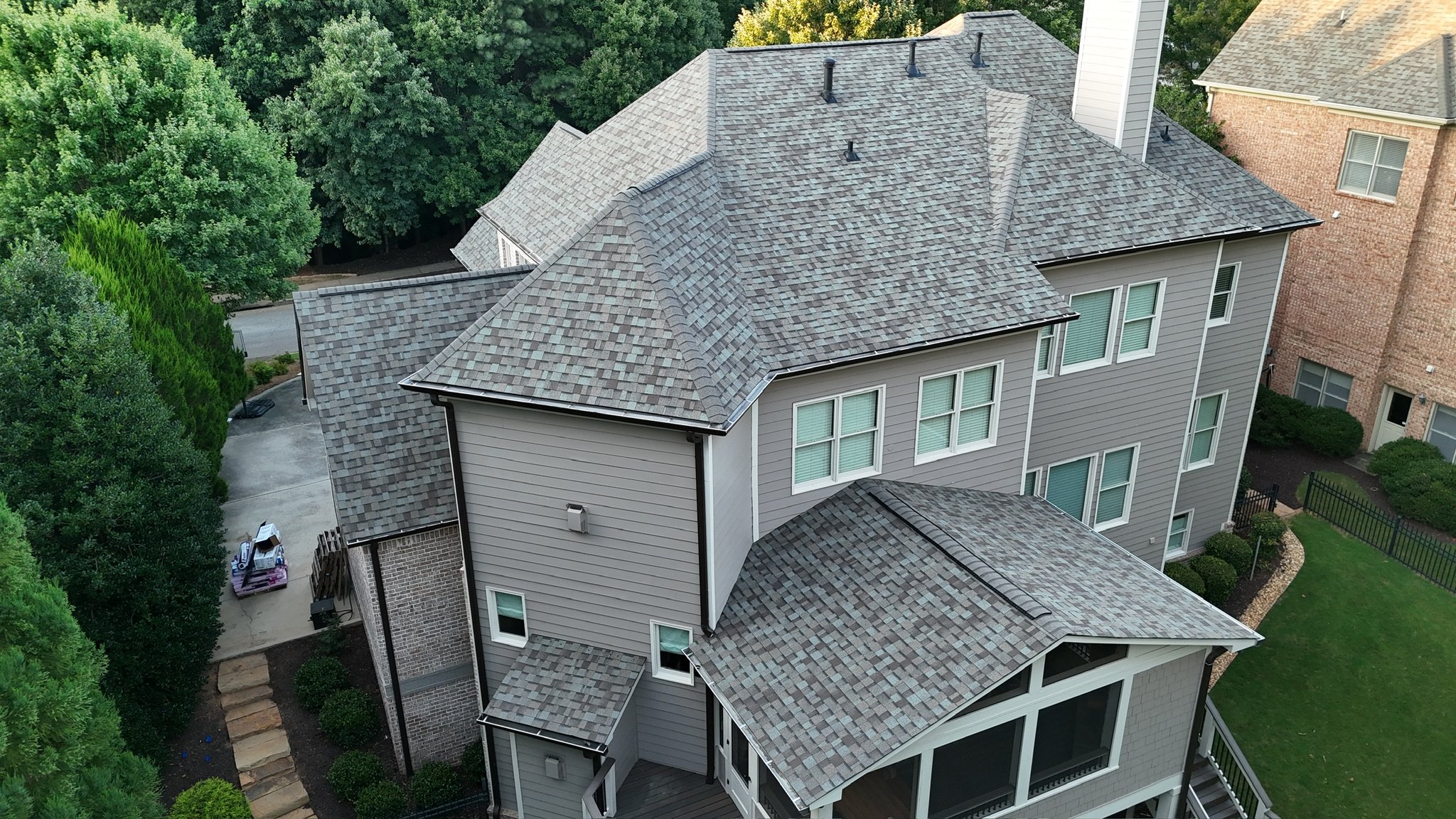Aerial view of the finished roof replacement on a three-story brick home in Marietta, GA