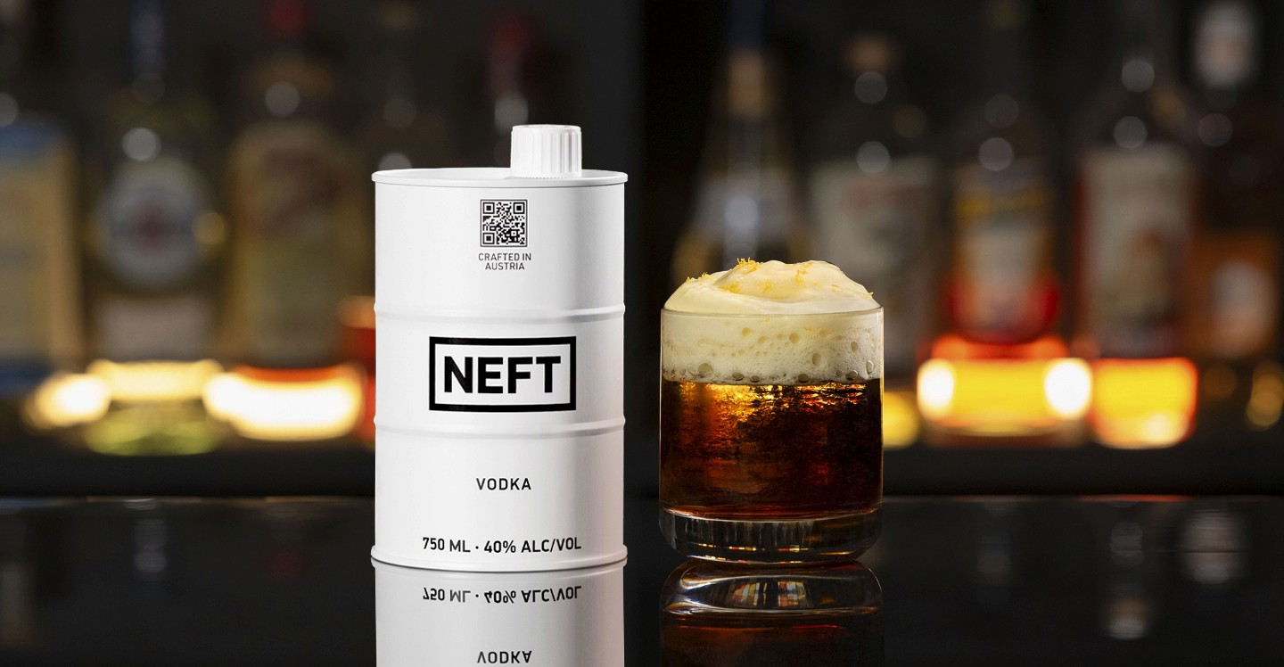 A NEFT Barrel and a glass of The Barr Americano on a bar counter.