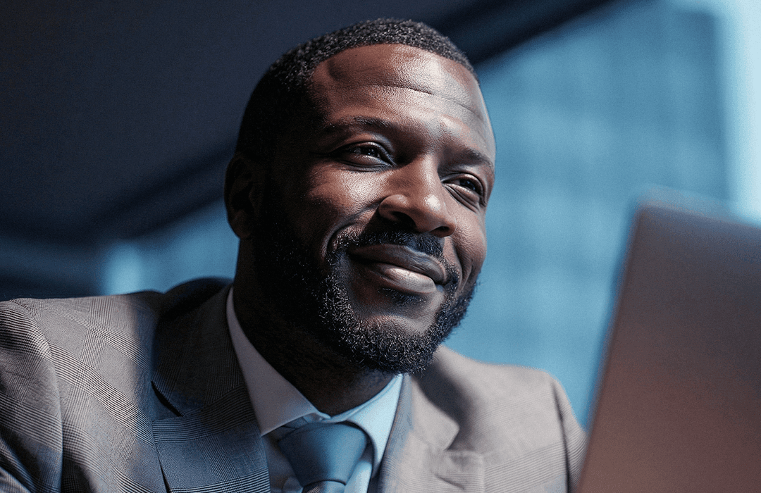 Advogado sorrindo e confiante ao trabalhar no notebook após tomar decisões para superar o custo da inação.