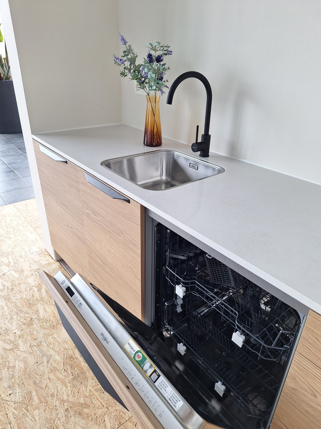 Close-up van de ingebouwde keuken met open afwasmachine.