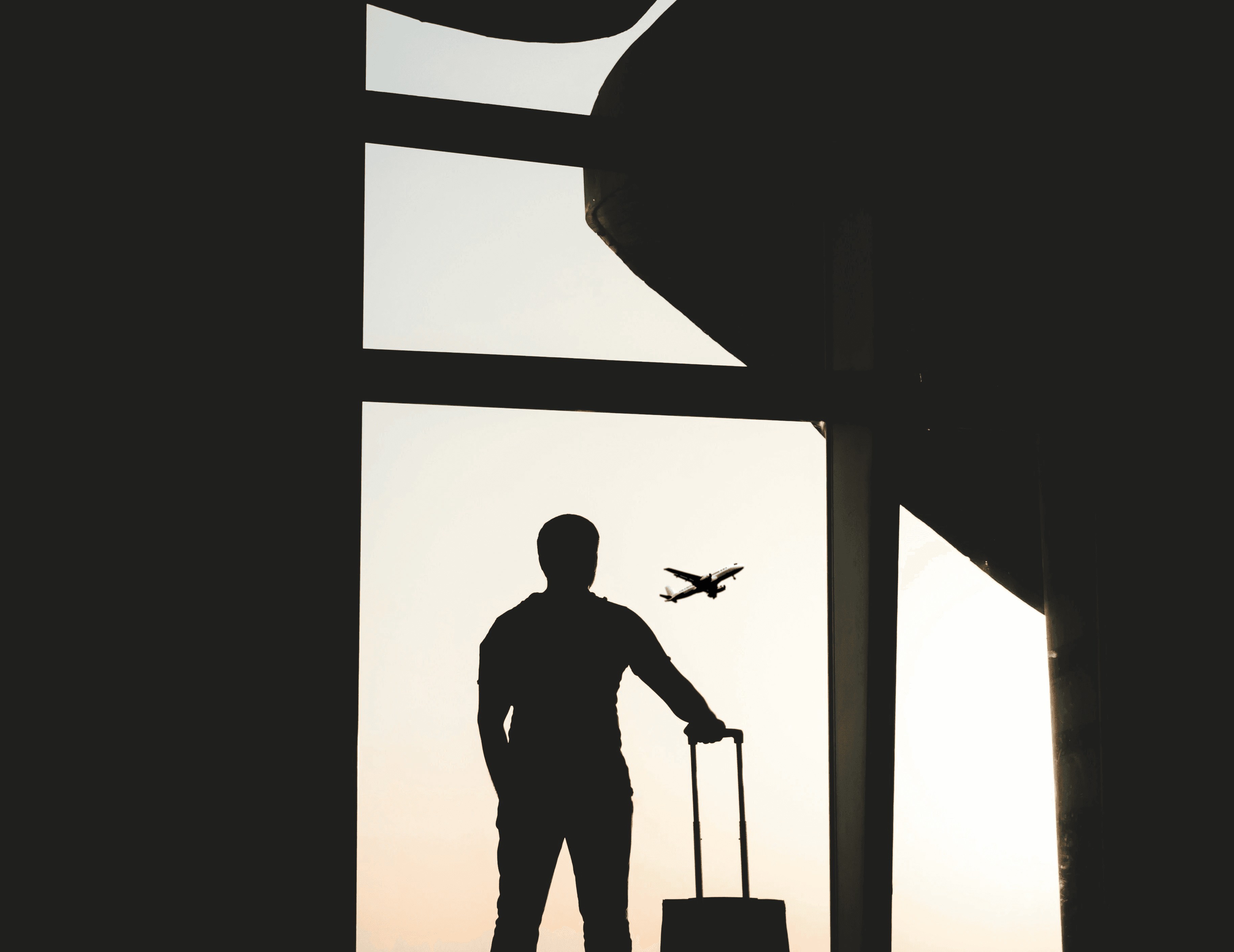silhouette of man holding luggage inside airport
