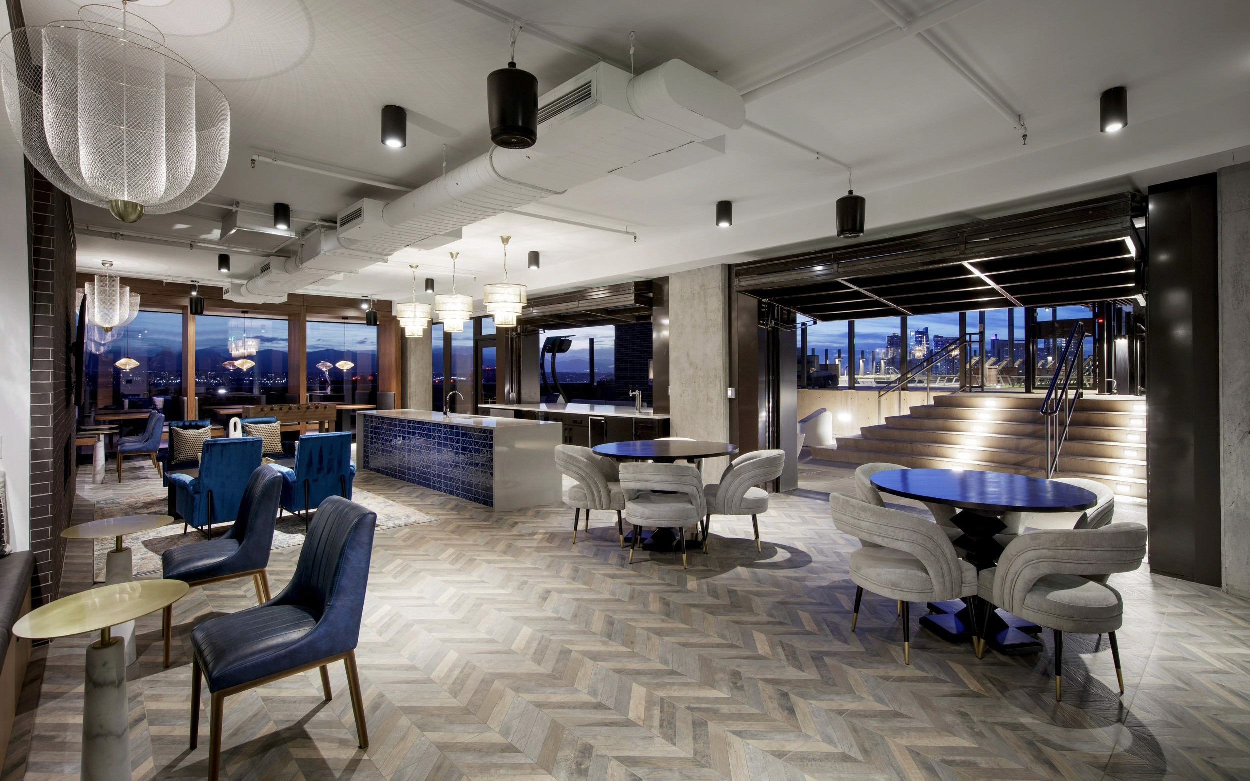 Modern lounge area with city view at dusk.