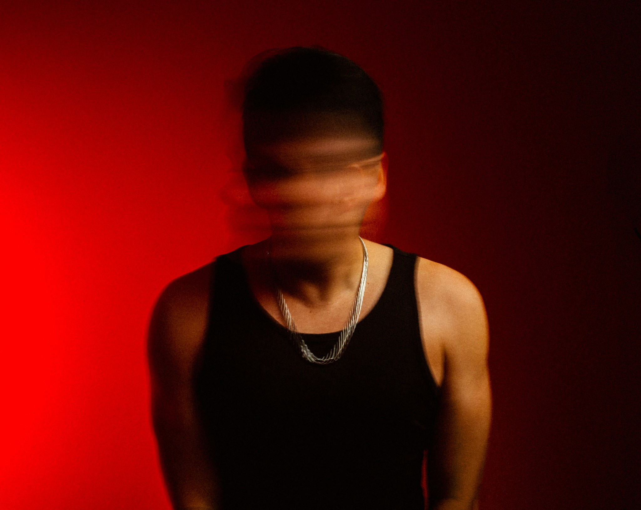 Person, holding a white rose behind his back with one arm on a light blue background