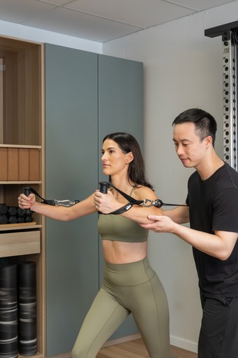 a woman holding two dumbs in a gym