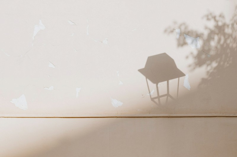 Shadow of a street lamp on a pale wall