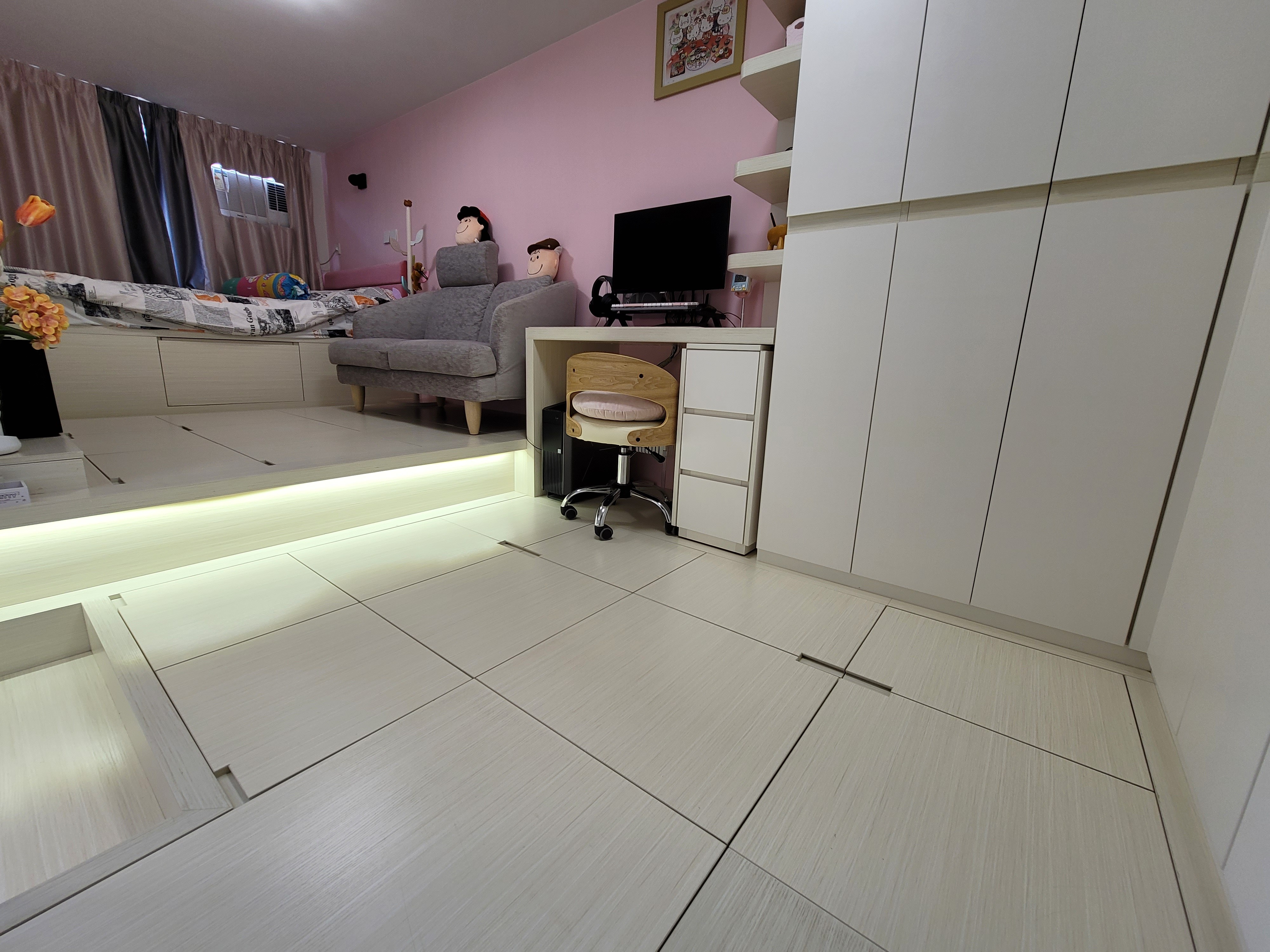 White built-in cabinetry and integrated desk with a wooden chair positioned on a tiled floor in a Hoi Tat Estate home.