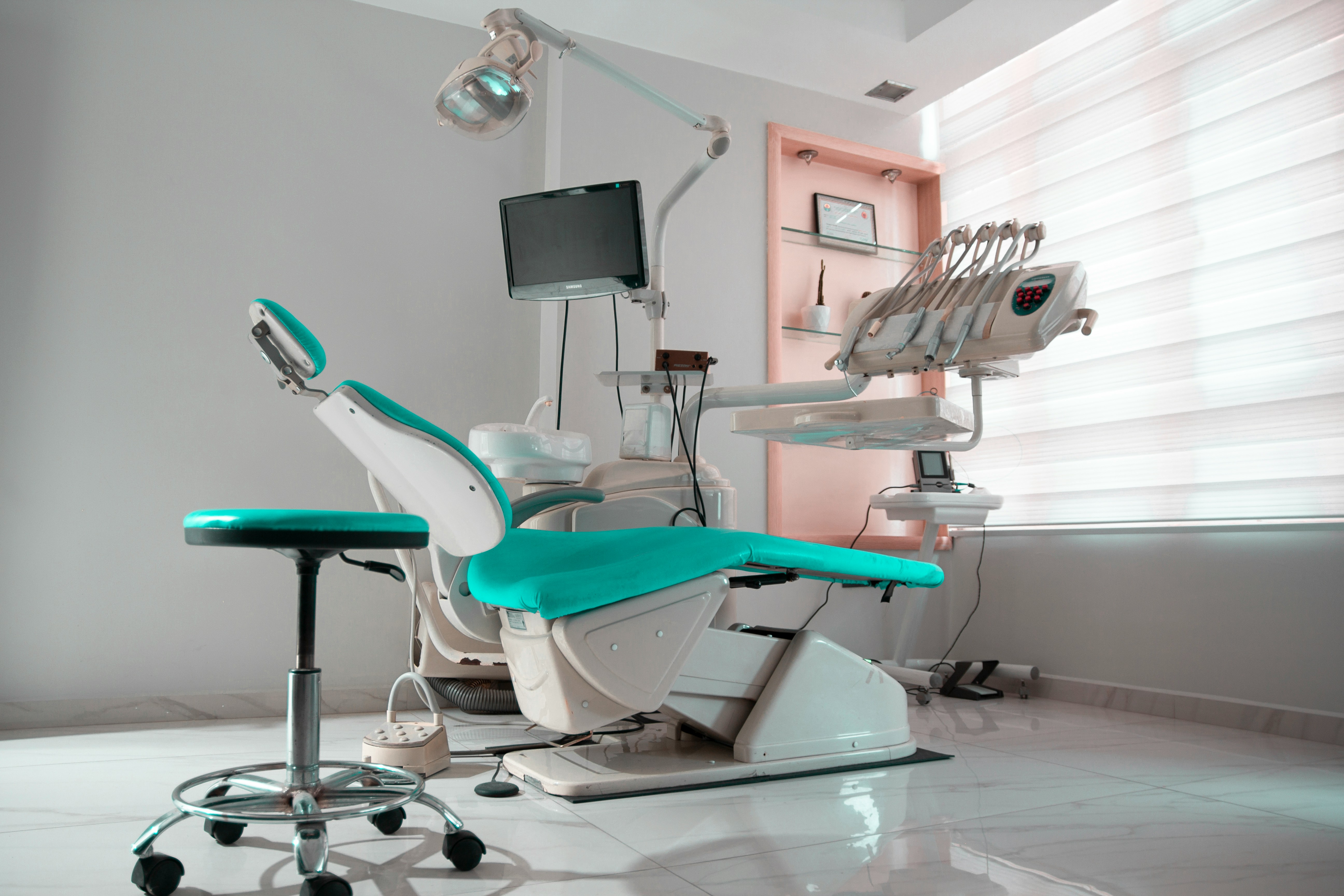 a dental room with a chair and a monitor