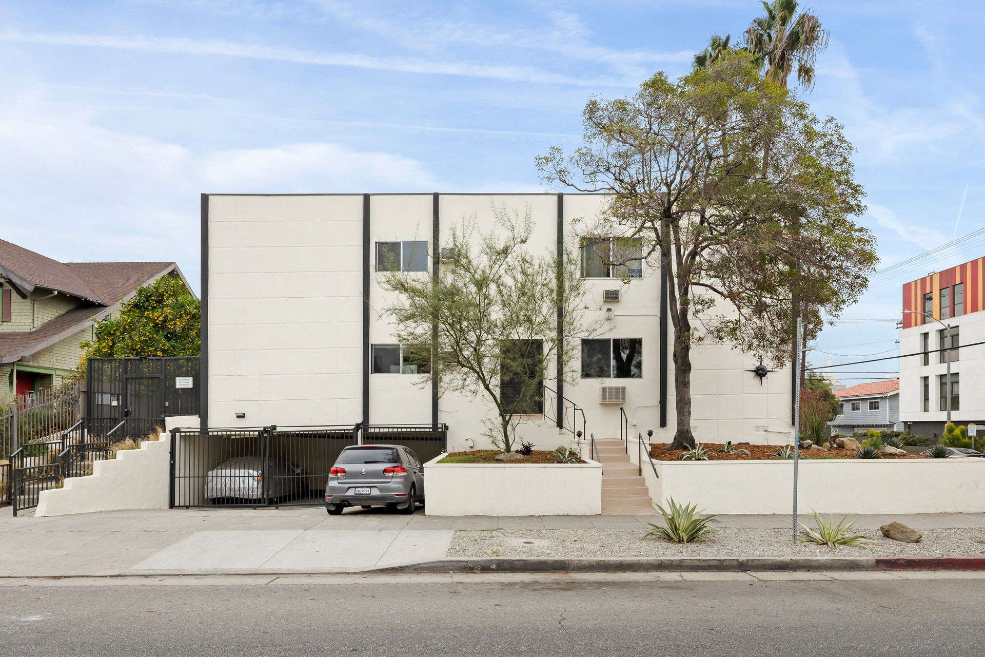 200 N Rampart front elevation showing renovated facade, gated parking area and mature street trees.
