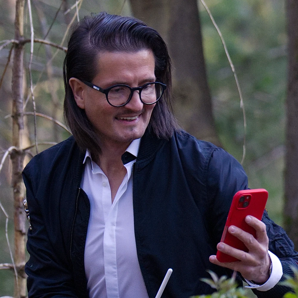 Lead Designer und Gründer prüft Inhalte auf einem mobilen Gerät und reflektiert Designentscheidungen.