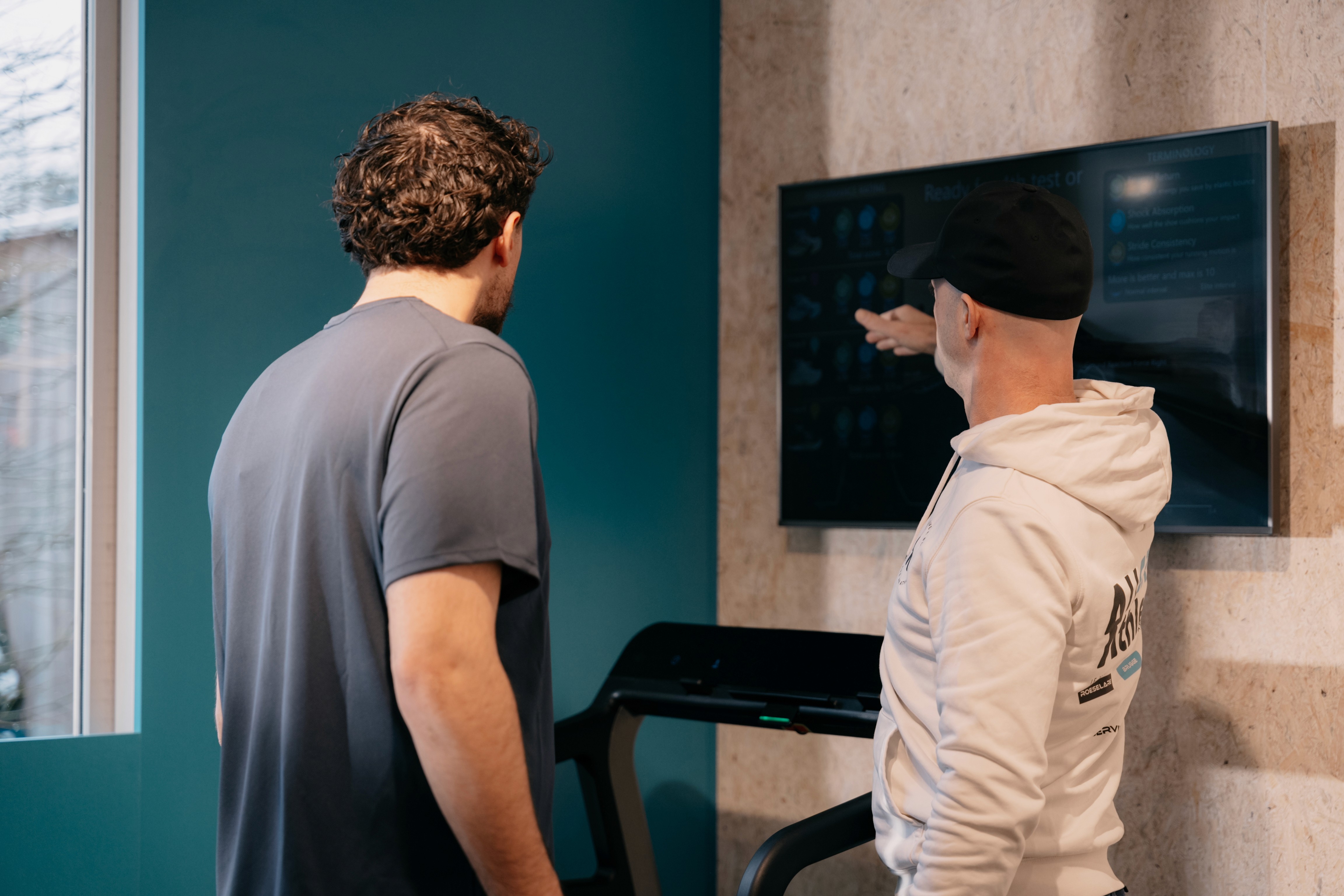 A large group photo of diverse team members gathered in an industrial-style space with arched ceiling.