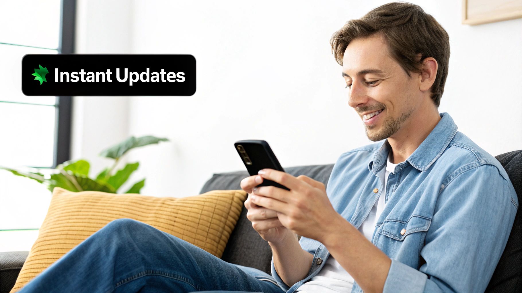 A smiling man sits on a sofa, looking at his smartphone, with an 'Instant Updates' banner.