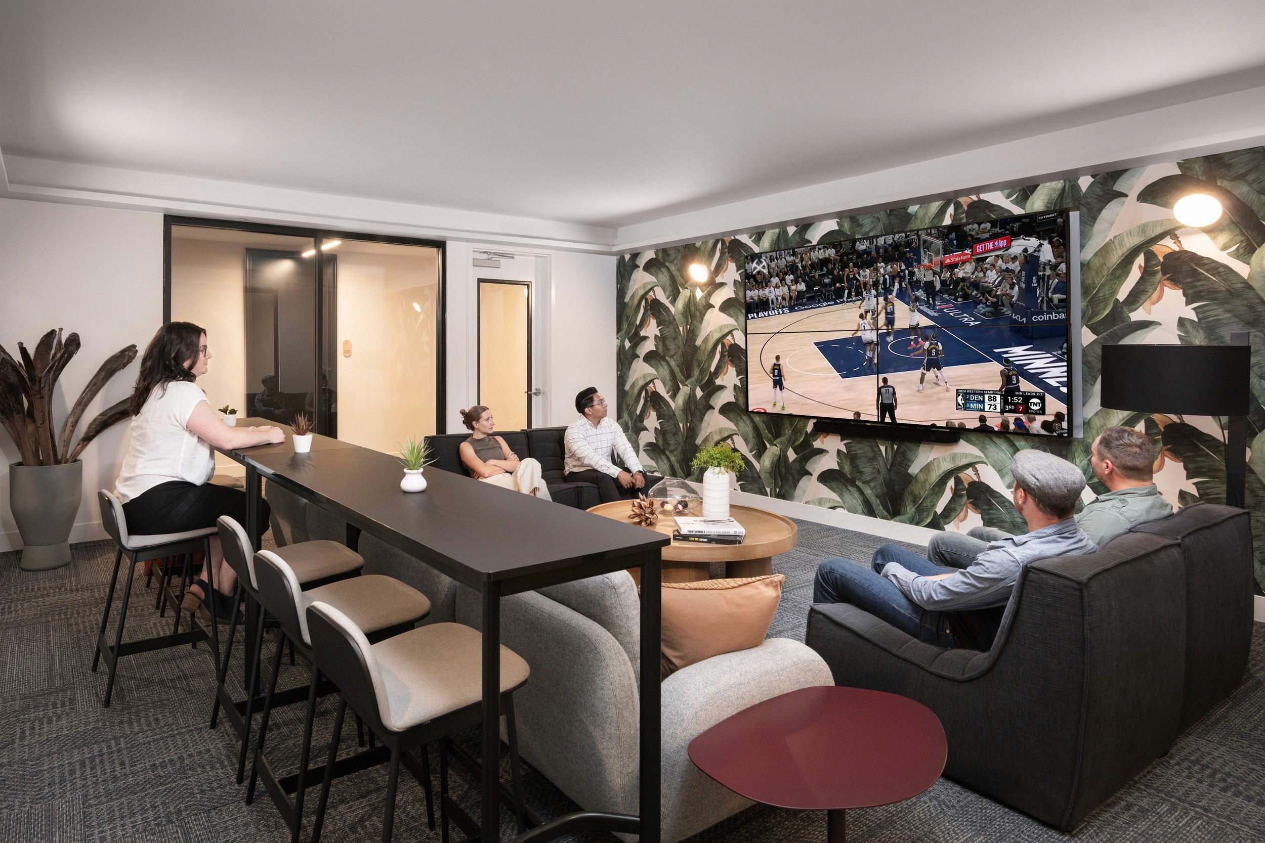 People watch basketball game on TV in lounge area