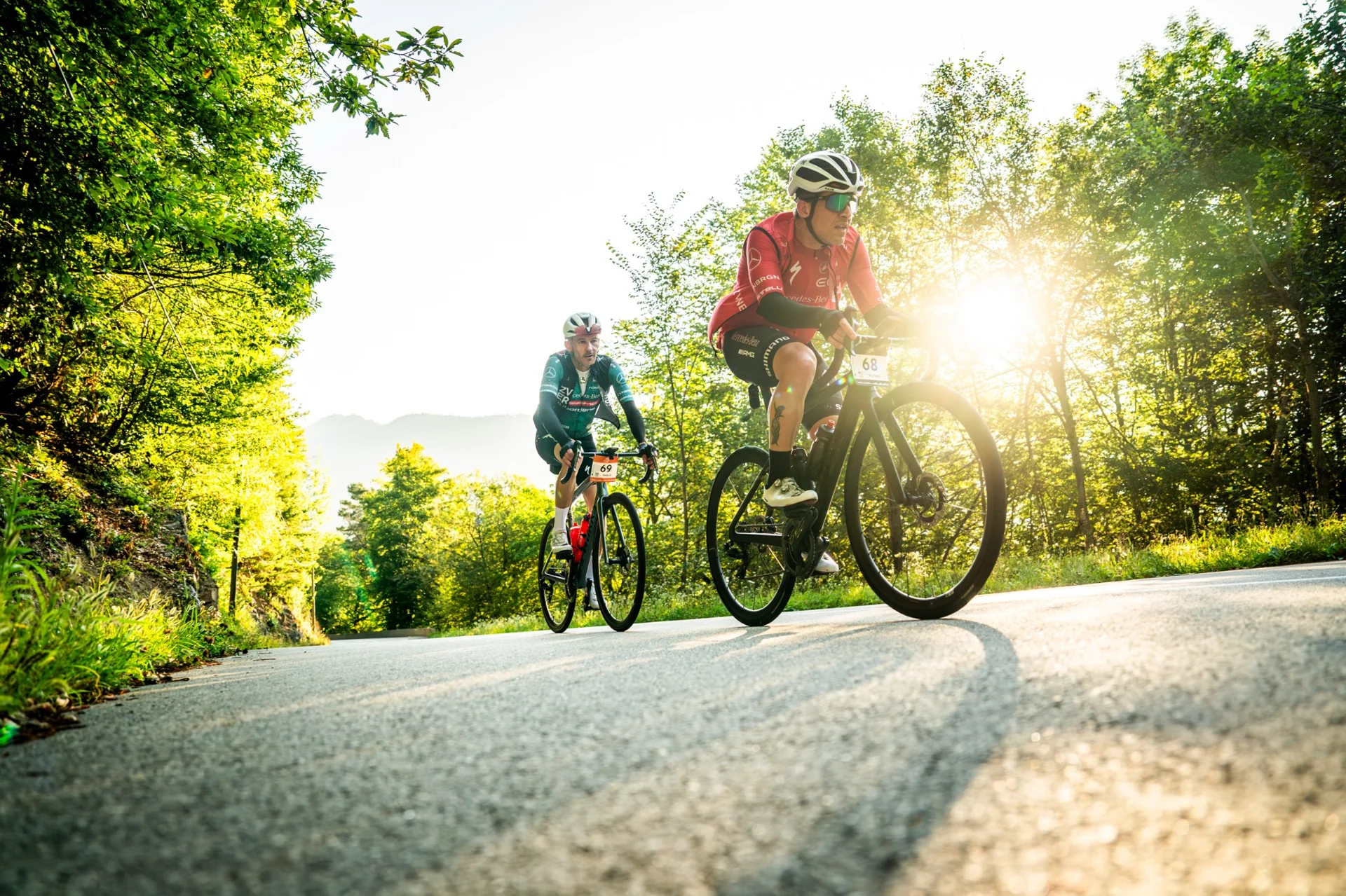 Cyclists in the sunrise light on Alpine roads - endurance and passion