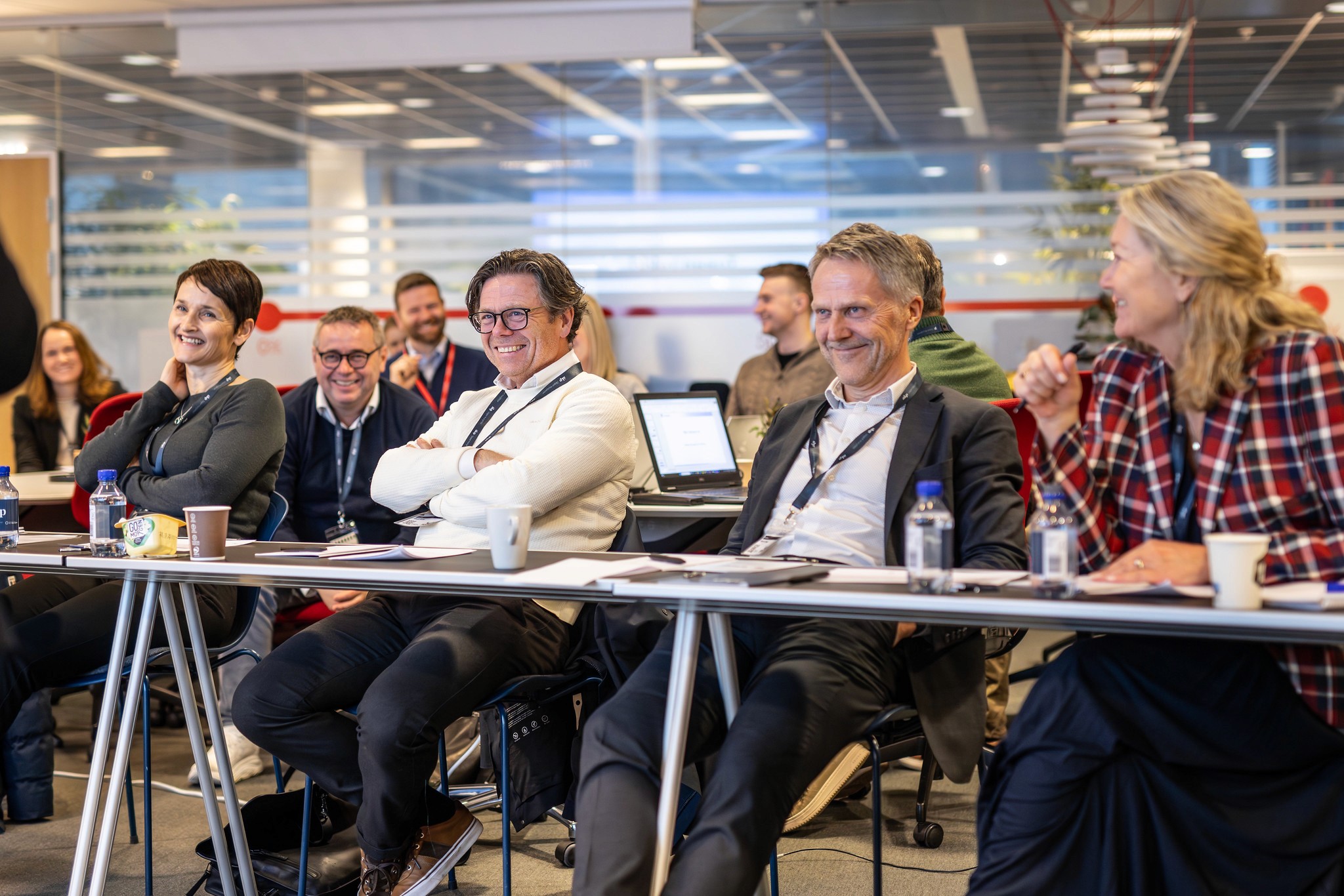 A person wearing a virtual reality headset stands in front of multiple screens, engaged in a digital experience.