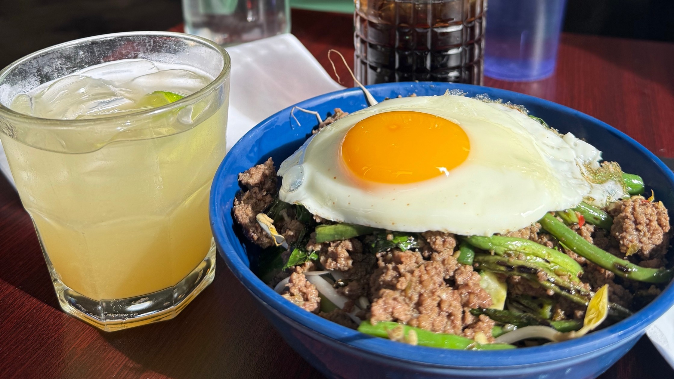 One of the best places to eat in Charleston SC, Xiao Bao Biscuit, serving up their Pad Kra Pao. It is a spicy Thai basil beef stir fry served over rice with a sunny side up egg, garnished simply and noted as gluten-free upon request.