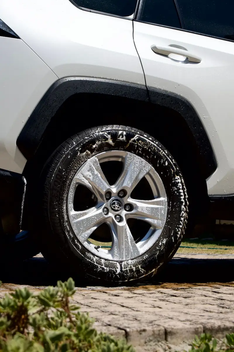 Image of a cars wheel with soap suds falling off. 