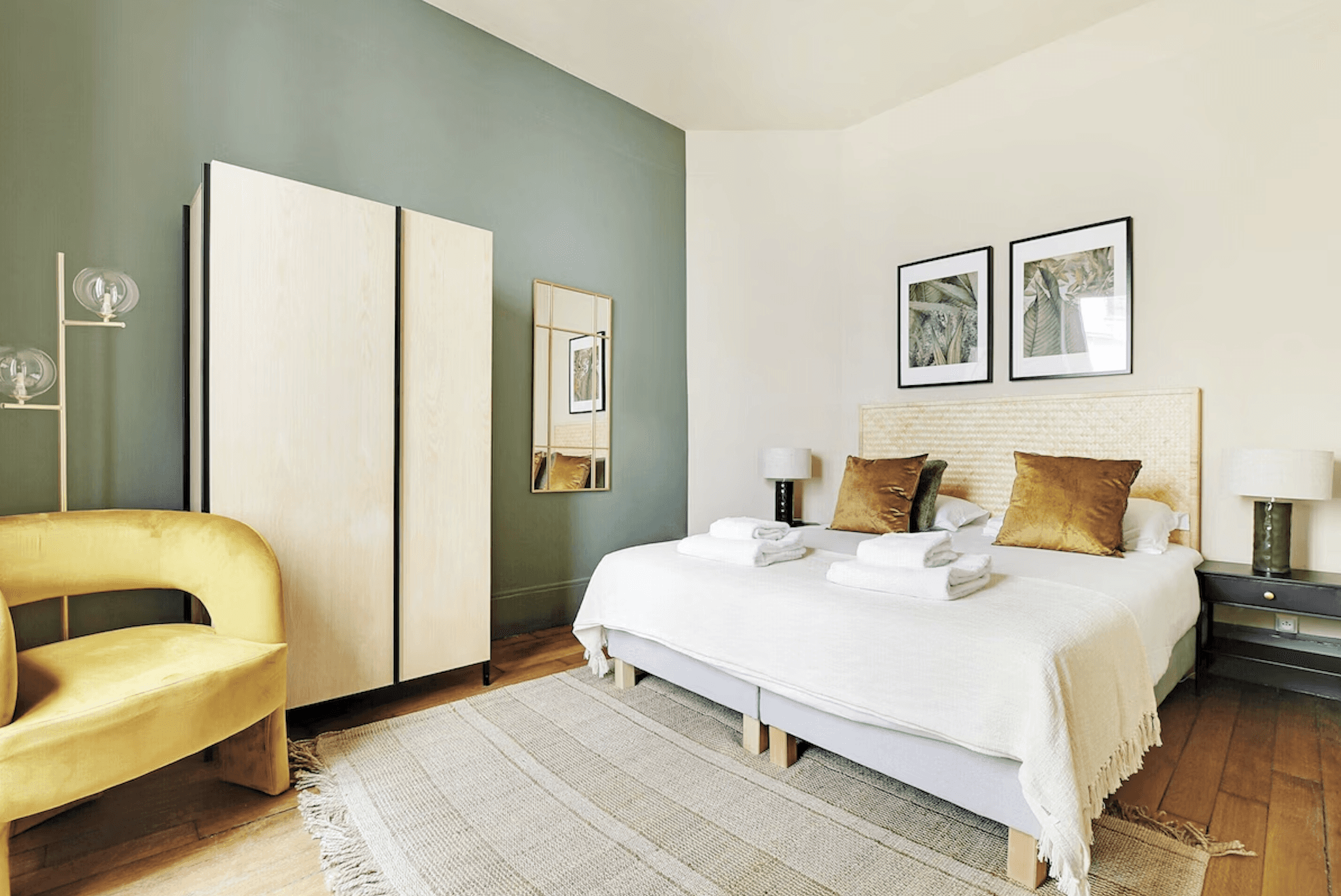 A modern, minimalist cliffside house with large glass windows offers stunning ocean views, surrounded by lush greenery and bathed in warm sunlight.